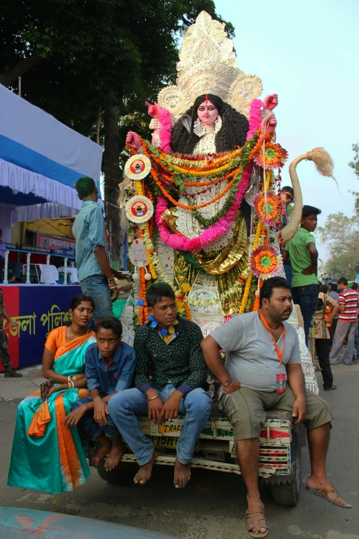 people riding on the back of a truck with an idol