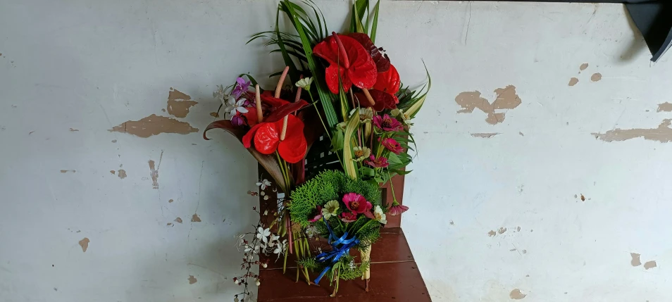 flowers on a ledge near the wall and coat rack