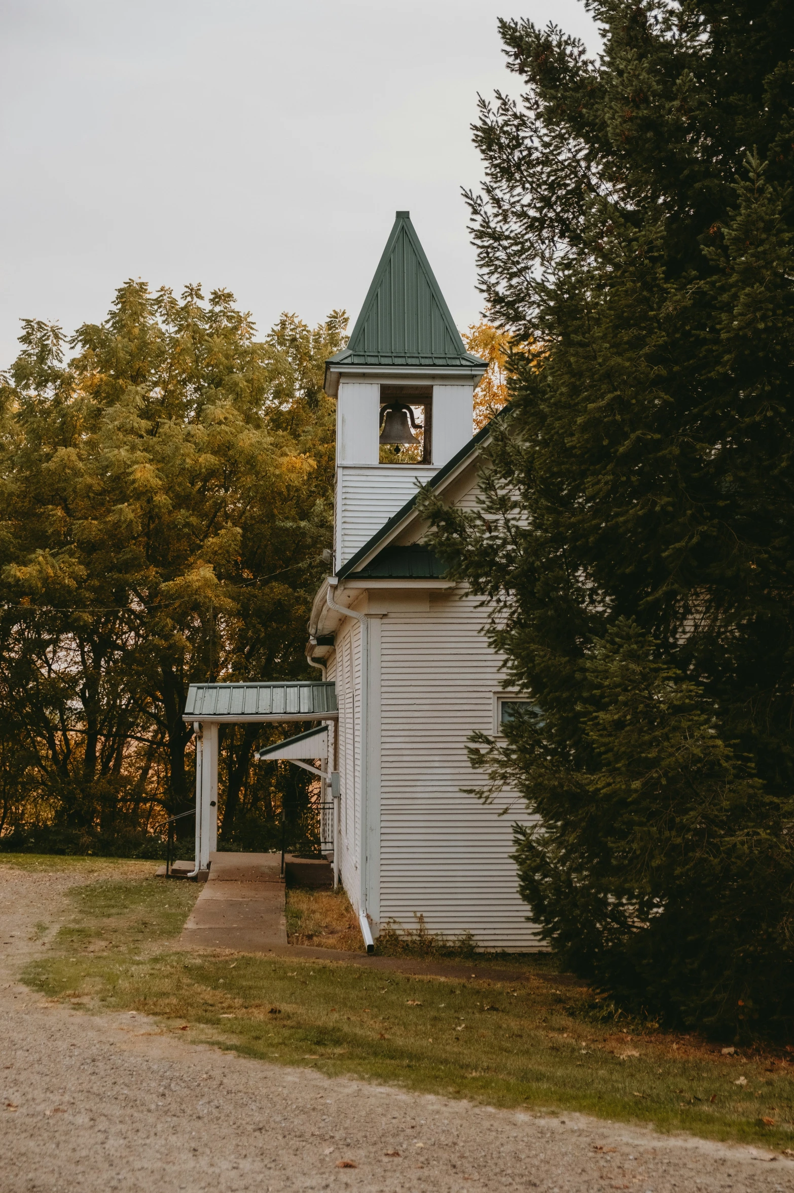 a church with a tower next to green trees