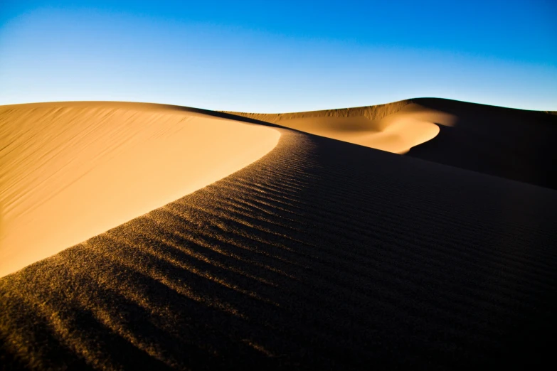 sand dunes and shadows against the blue sky