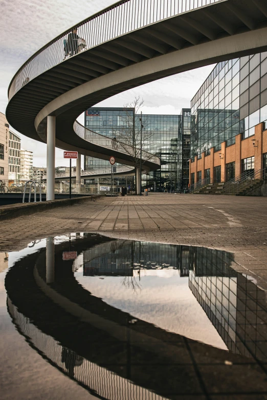 a large glass building next to a circular pool