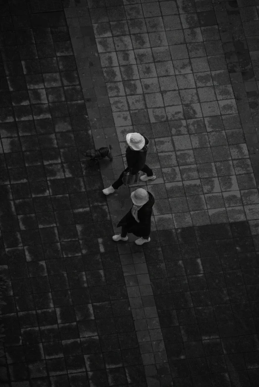 a black and white image of two people wearing hats