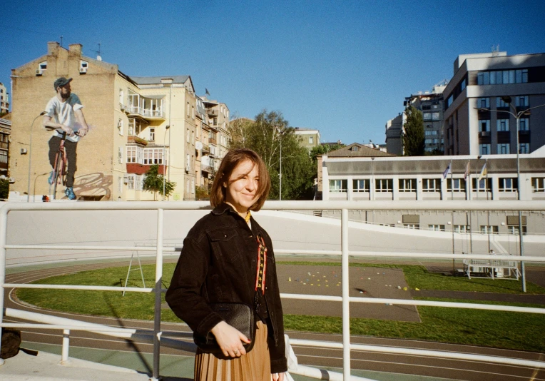 a woman smiles while standing on a bridge