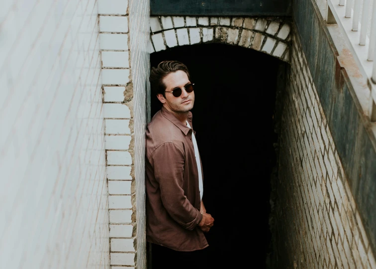 a man wearing sunglasses standing at the entrance to a room