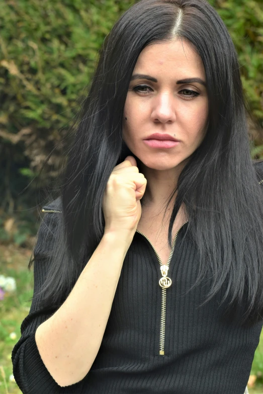 a woman with long dark hair is holding her fist