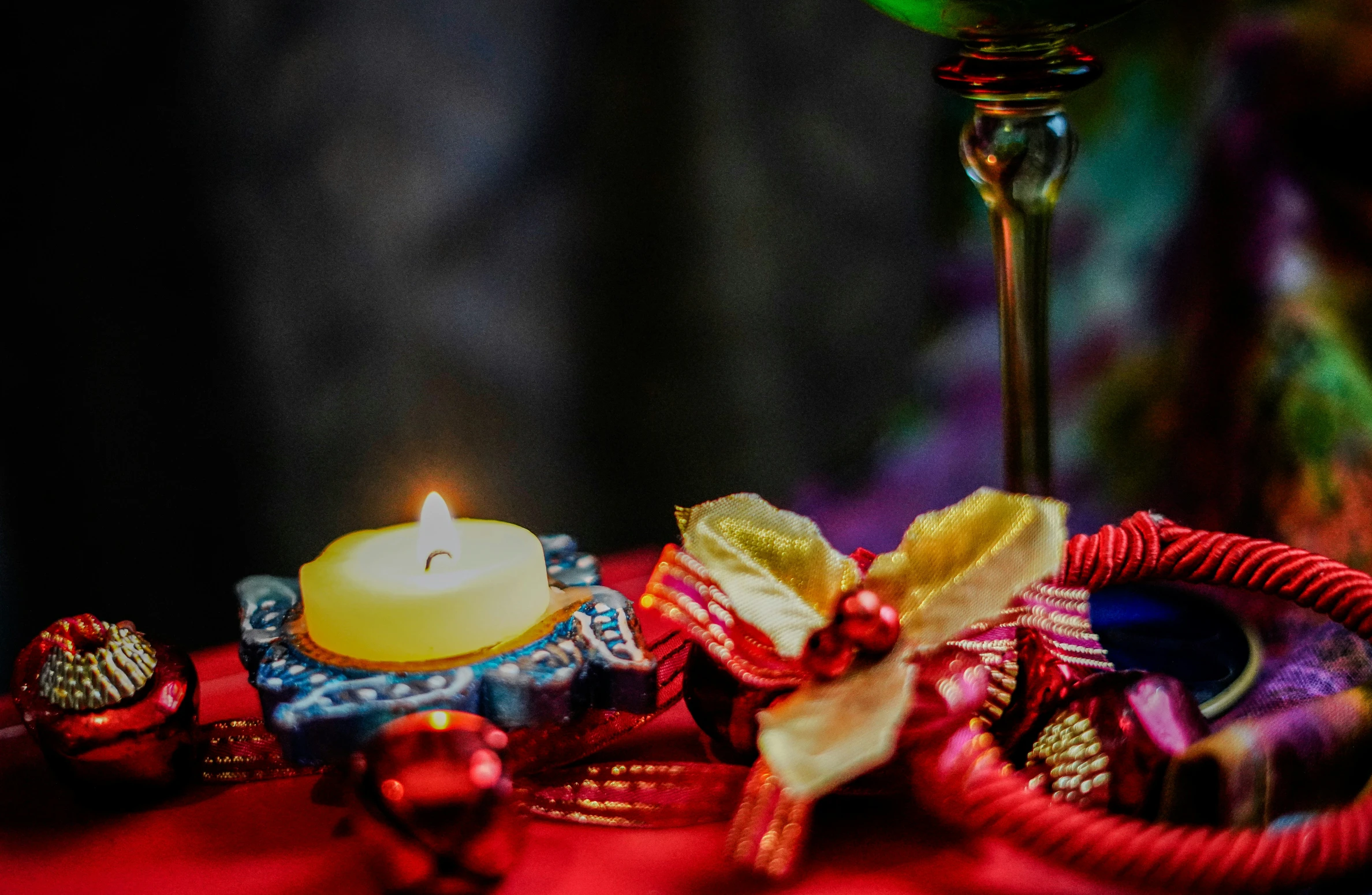 a candle and ornaments on a red cloth