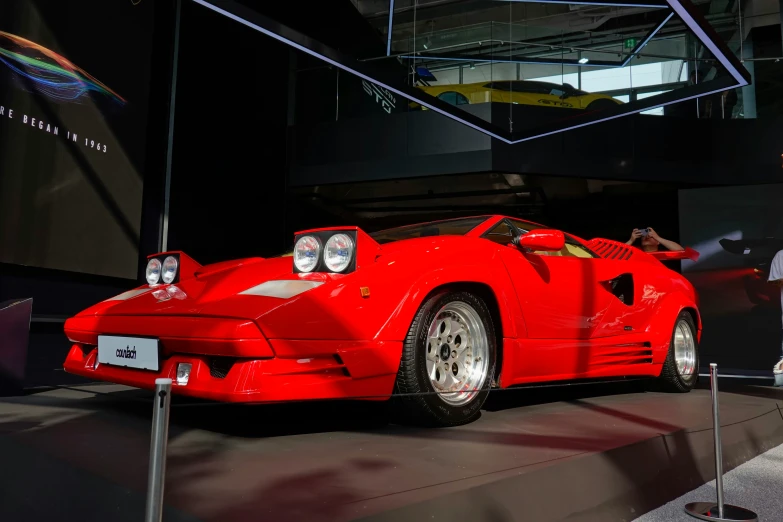 a red sports car on display in a building