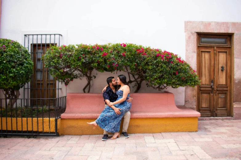 an affectionate couple hugs on a step under a plant