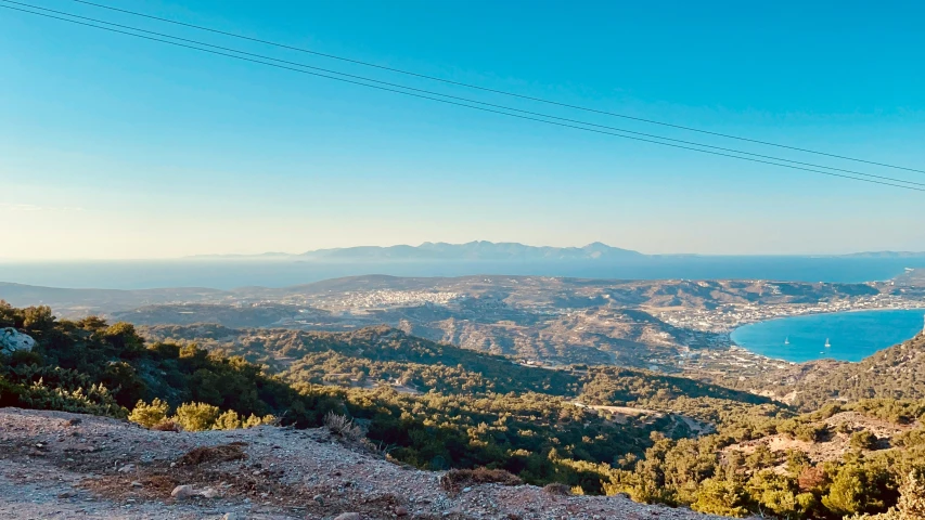 two people sit on a mountain, with a view over a lake and mountains