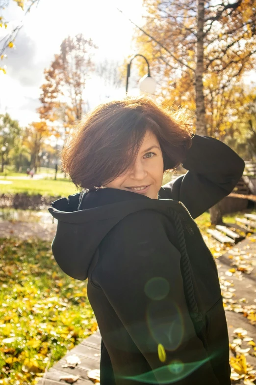 a woman poses for a picture while in the fall