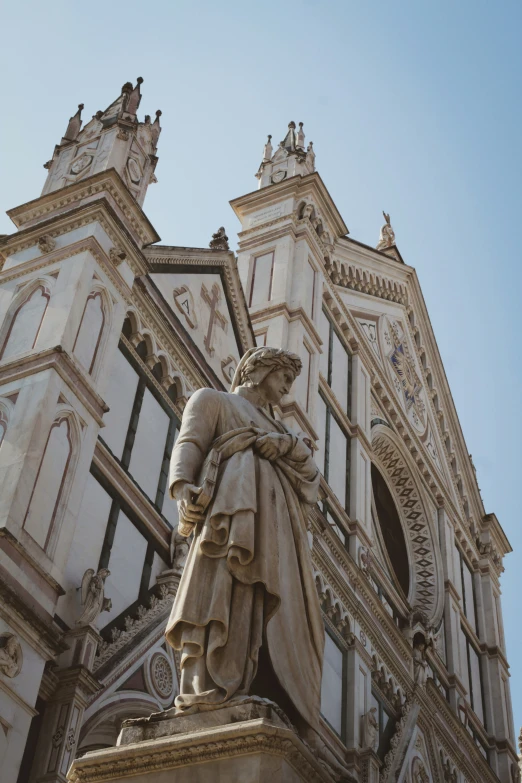 a statue next to a tall building with two towers