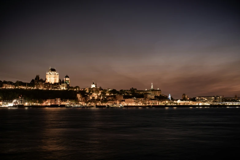 the city lights shine brightly as viewed from across the water