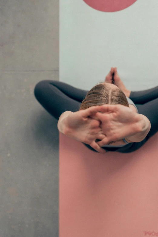 a person is lying on a yoga mat holding their hands together