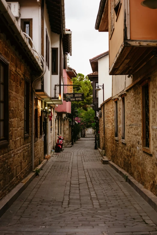 cobblestone street lined with homes and a car parked on side of building