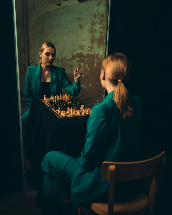 two women sitting at a chess table in a dark room