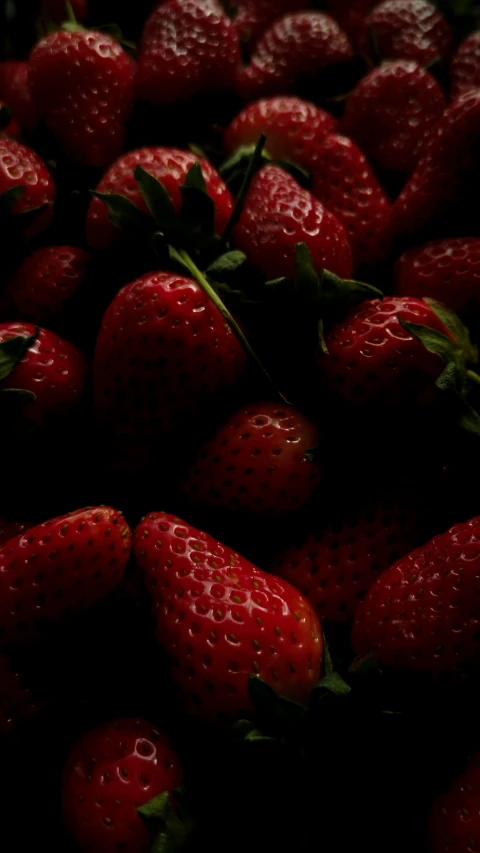 a bunch of ripe strawberries is gathered together