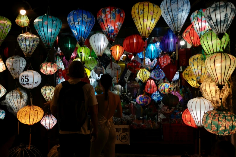 people standing around with colorful lamps behind them