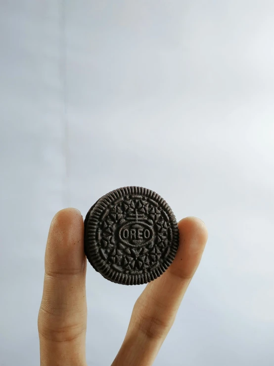 the chocolate oreo is in someones hand