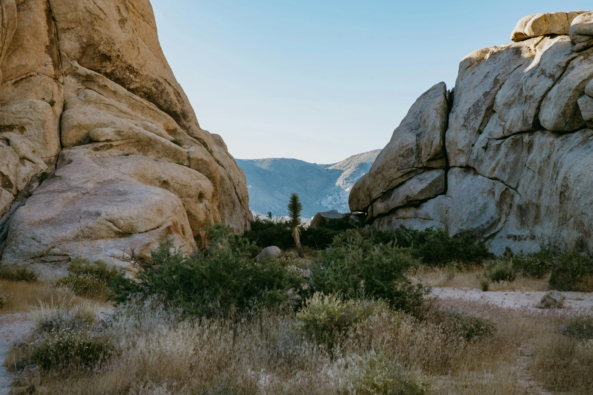 a man hiking down the path between two large rocks