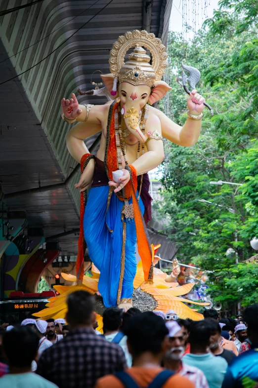 an idol is standing among a crowd of people