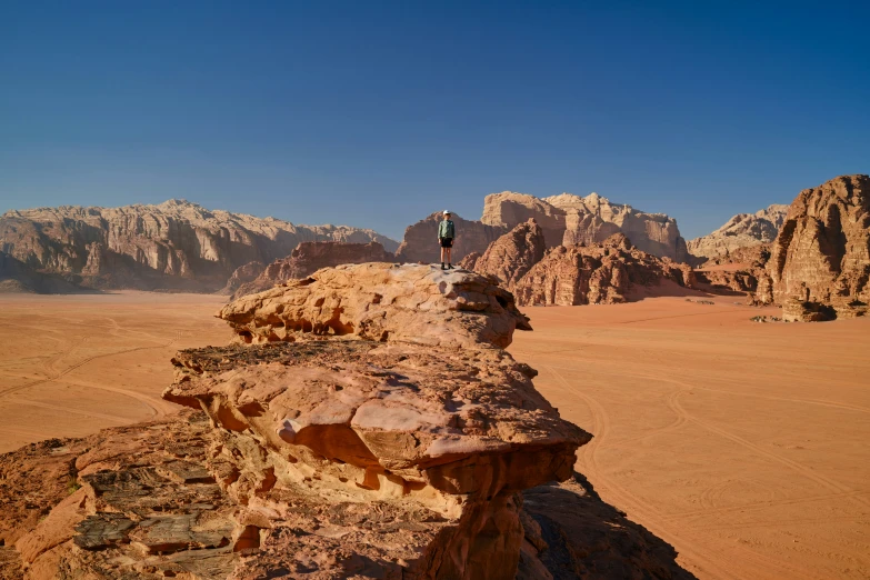 the person is on the top of the cliff with many mountains in the background