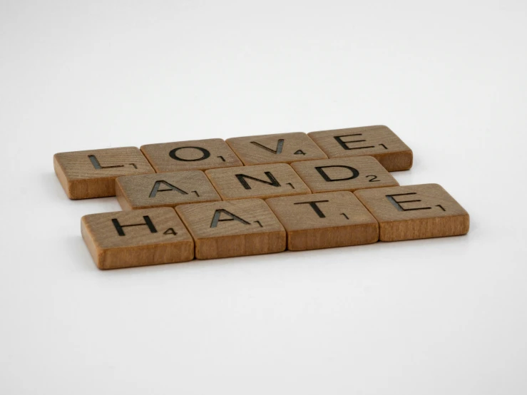 two scrabbles are on the floor with words that say love and hate