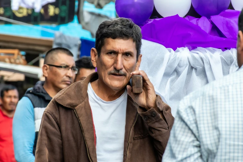 a man with a mustache talks on the phone