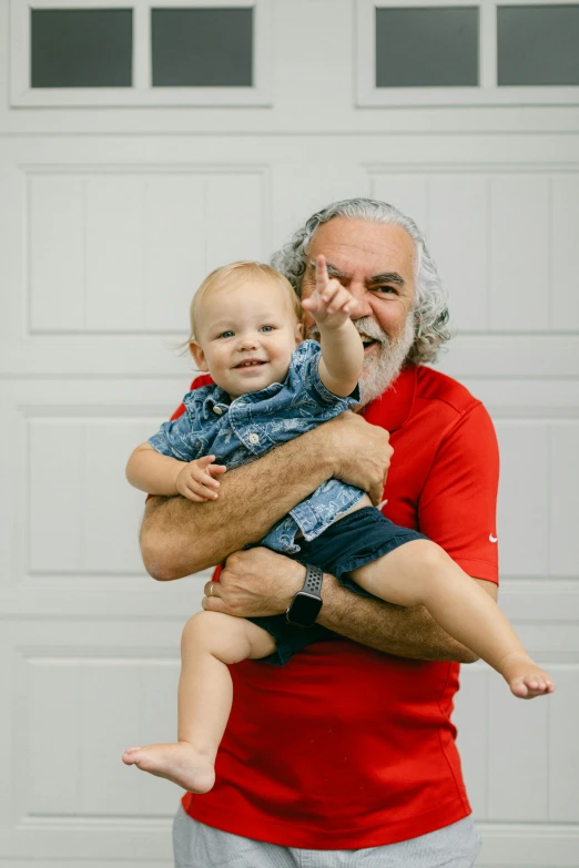 man holding a toddler by a garage door