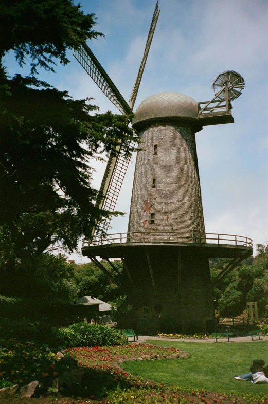 a large windmill sits high in the sky