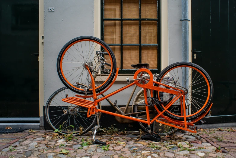 an orange bike parked outside a building