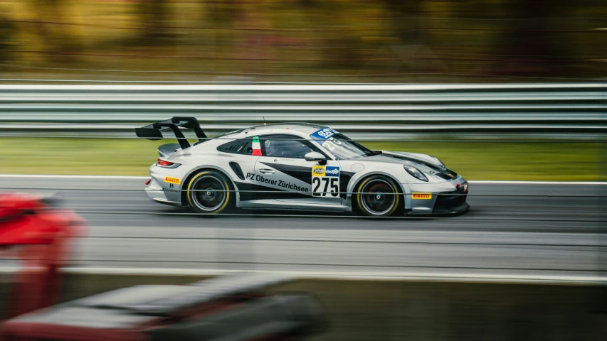 the porsche cup car drives down the race track