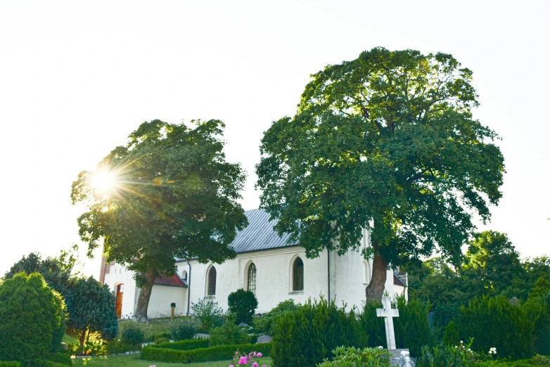 a church and cross in the foreground, at sunset