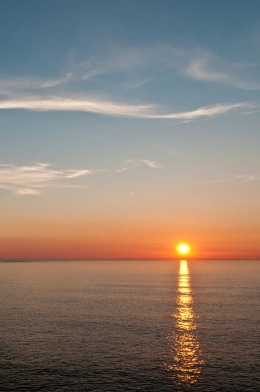 the setting sun shines on calm water