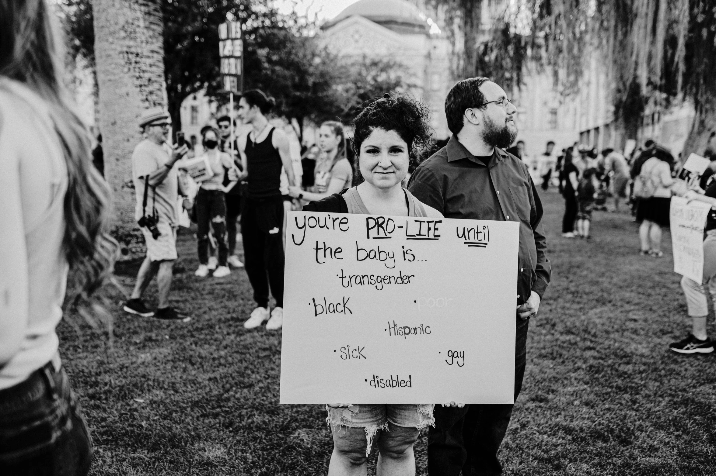 a group of people are standing outside holding signs