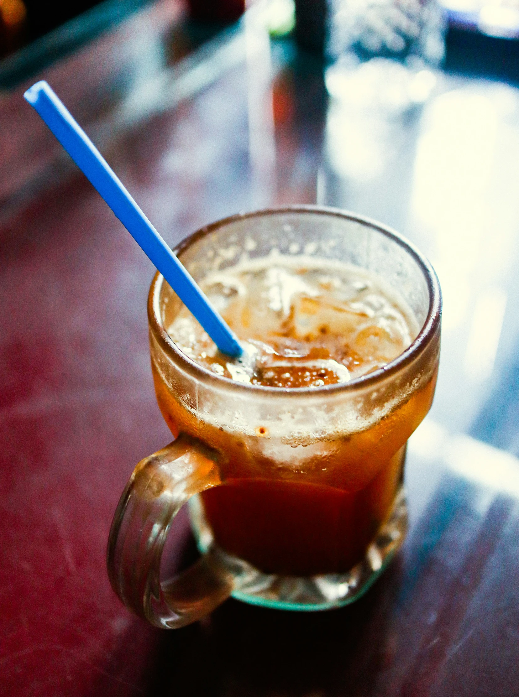 a glass filled with iced beverage sitting on a table