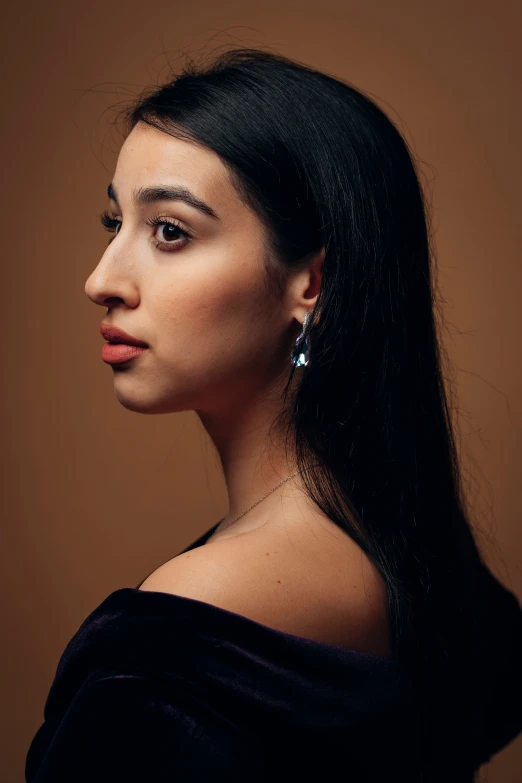 a woman with long black hair and big earrings