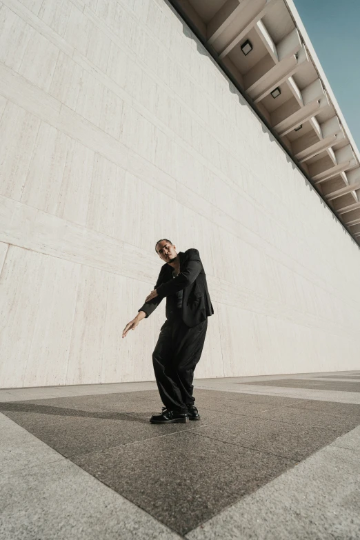 a man dressed in a business suit standing next to a wall