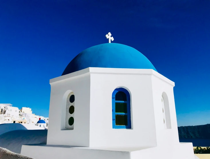 a blue and white building with a cross on top