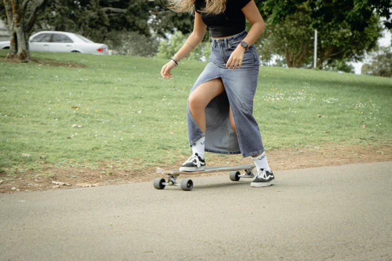 a woman wearing denim clothes on a skateboard