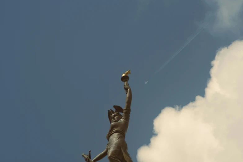 a statue holding a bird in its hand while looking up