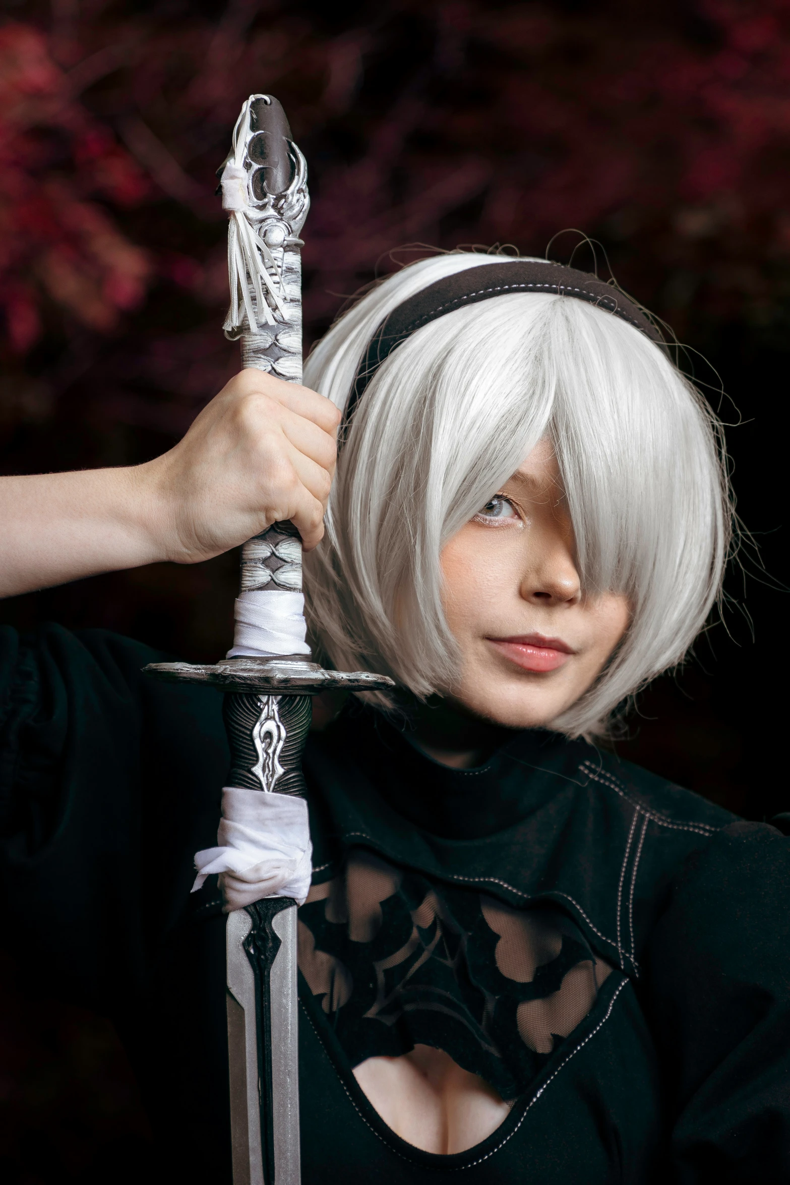 a woman holding an elaborate sword near her head