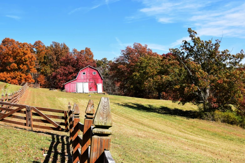 a field with a fence and a barn