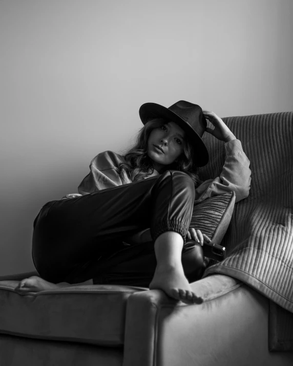 a person laying on a couch with their feet on the armrest