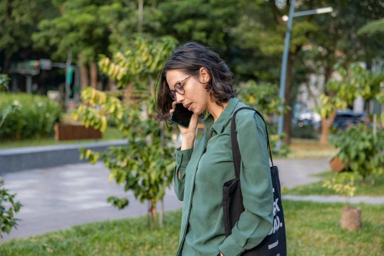 woman walking down a sidewalk talking on her phone