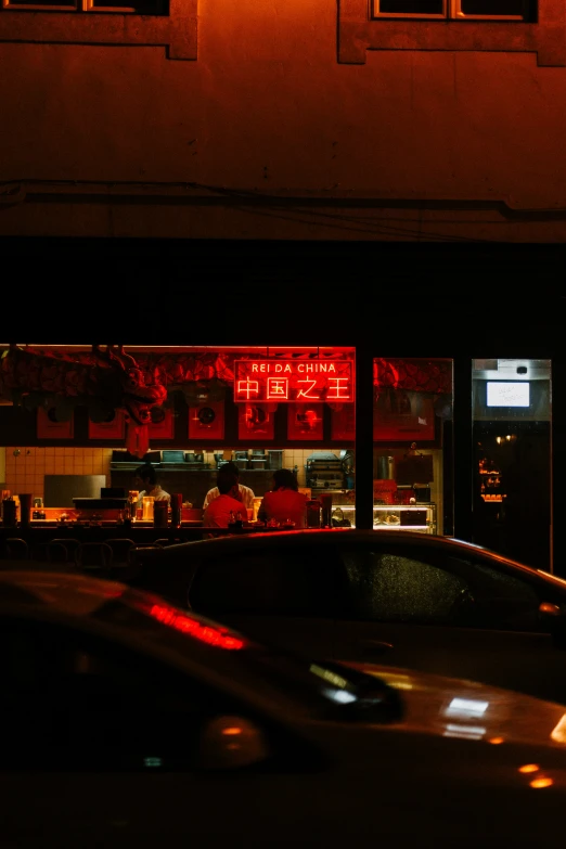 car passing by a diner at night, on the street