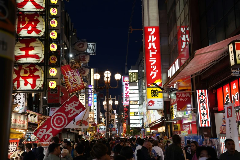 the street is filled with people and lit up signs