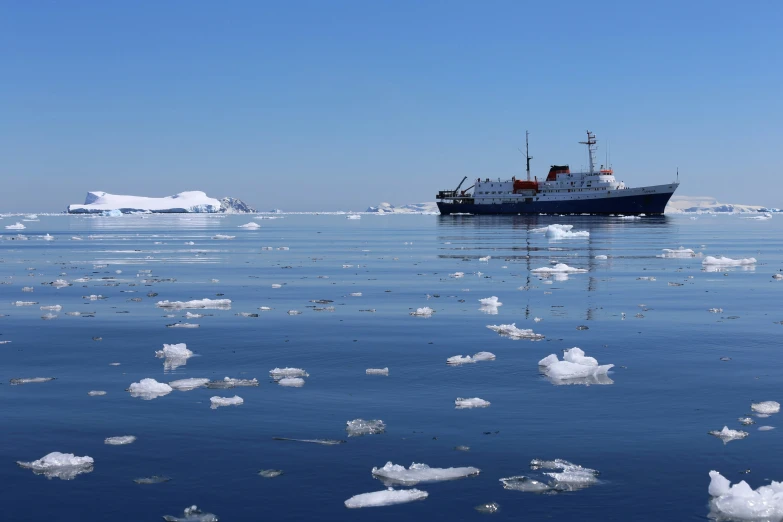 the icebergs are melting in the water as a boat sails on the ocean