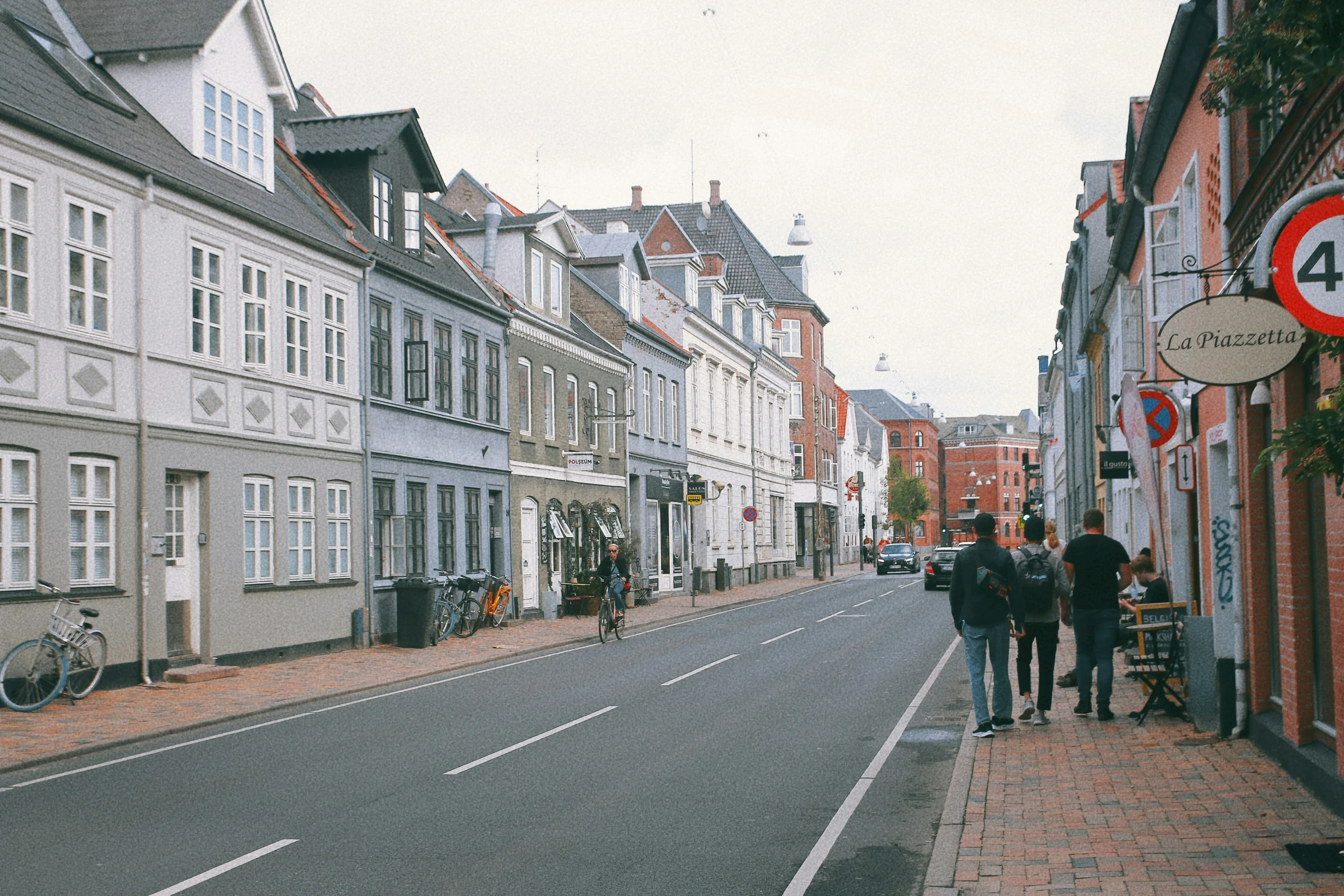 several people walk down the street in an urban setting