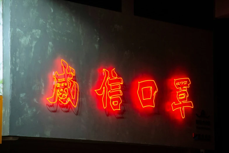 neon signs that read chinese on a white wall