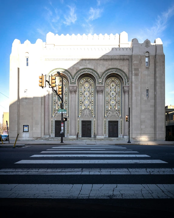 an empty intersection has a large building with columns